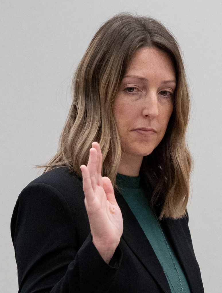Dr. Caitlin Bernard raises her right hand as she is sworn in during the hearing on May 25, 2023 at the Indiana Government South building in Indianapolis. 